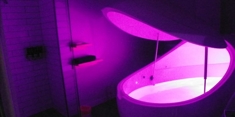 Float tank illuminated inside a float pod room